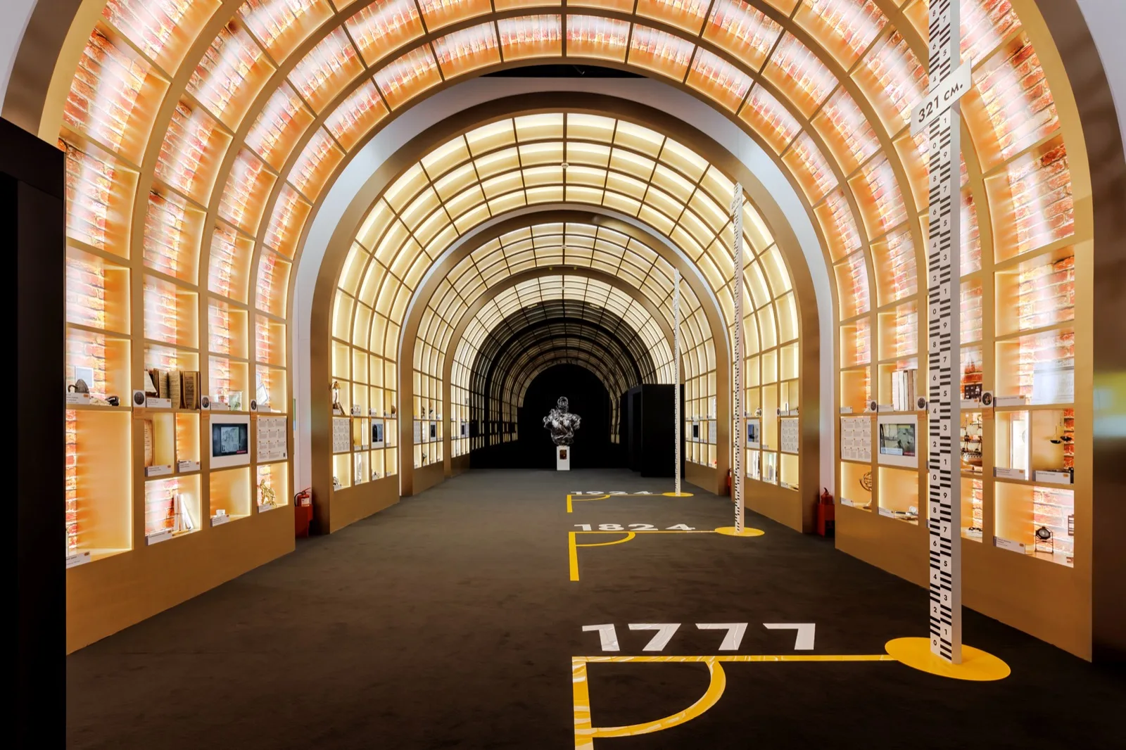 History tunnel: display cases with original artifacts and dates underfoot